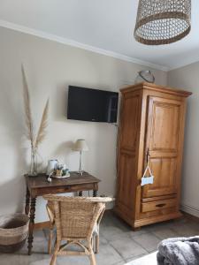 a room with a desk and a tv on a wall at Les Chambres D'Anel in Saint-Pourçain-sur-Besbre