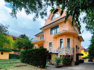 a large orange building with a balcony on top at Villa Kristal Hotel in Budapest