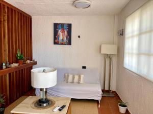 a living room with a couch and a table with a lamp at Departamento chichan nah in Progreso