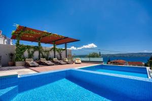 a swimming pool with a view of the water at LUXURY VILLA PARADISE 120m from sandy beach, heated pool, billiard, max 12 pax in Duće