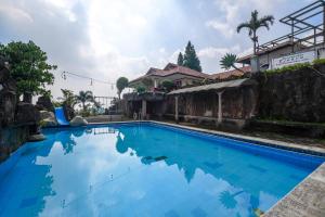 a large blue swimming pool next to a building at Villa Tjokro 1 By ARBA in Sampal 2