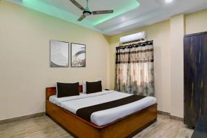 a bedroom with a bed and a ceiling fan at Hotel O Eastern Crossway Siliguri Formerly Utsho in Siliguri +31 photos