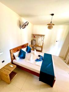 a bedroom with a large bed with blue pillows at The Sanctuary in El Nido