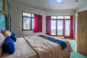 a bedroom with a large bed and two windows at Villa Tjokro 1 By ARBA in Sampal 2