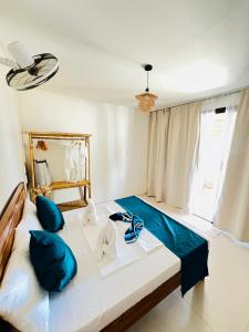 a bedroom with a bed with blue pillows at The Sanctuary in El Nido