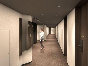 a woman walking down a hallway in a building at Nest hotel alt Sapporo Odori in Sapporo