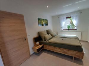 ein Schlafzimmer mit einem Bett, einem Fenster und einer Tür in der Unterkunft Am Wolfsbach in Helferskirchen