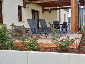 Eine Gruppe von Stühlen steht auf einer Terrasse in der Unterkunft Am Wolfsbach in Helferskirchen