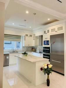 a large kitchen with white cabinets and a vase with flowers at 温哥华温西别墅民宿47 in Vancouver