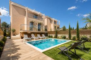 a house with a swimming pool and chairs in the yard at Efilenia Luxury Villas in Corfu