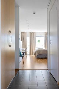 a room with a bedroom with a bed and a desk at Bella Luna Strandnära in Skummeslövsstrand