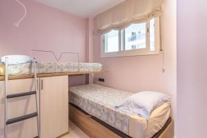 a small room with a bunk bed and a window at Maria apartment in Blanes +14 photos