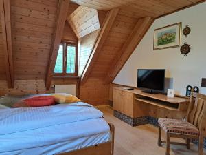 a bedroom with a bed and a desk with a television at Hotel Bezold in Rothenburg ob der Tauber +20 photos