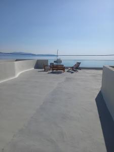 two benches and a table on the beach at I have a big dream in Agia Pelagia