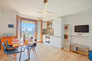 a kitchen and dining room with a table and chairs at Il Vecchio Faggio: Lake Maggiore view Terrace - Happy Rentals in Gignese