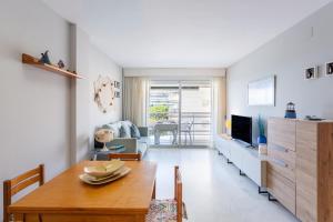 a living room with a dining table and a television at Maria apartment in Blanes