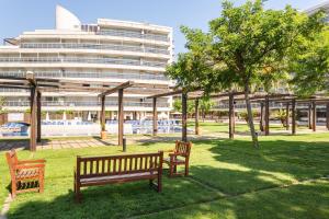 a park with two benches and a large building at Maria apartment in Blanes