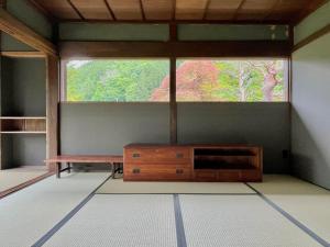 ein Zimmer mit einem Fenster, einer Bank und einem Tisch in der Unterkunft Room 48 in Takayama