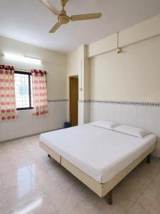 a bedroom with a large white bed with a ceiling at Hotel Shree Jay Amba Deluxe in Jaisingpur