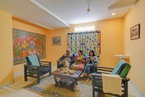 a group of people sitting on a couch in a living room at FabHotel Sun Mint - Jubilee Hills in Hyderabad