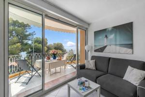 a living room with a couch and a balcony at Studio Azur with Sea View Terrace - Happy Rentals in Cap d'Ail