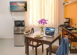 a kitchen with a table with a laptop on it at Centro Mornings, King & 2BR Suites, Sleeps 2-8, Kitchen WiFi AC, Beach, 5th Ave, ADO & Ferry 4 Min in Playa del Carmen +32 photos