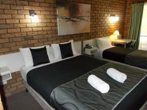 Ένα ή περισσότερα κρεβάτια σε δωμάτιο στο Park House Motor Inn