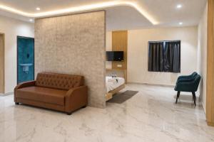 a living room with a couch and a bed at Golden Tulip Peddapally in Peddapalli