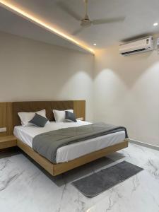 a bedroom with a large bed in a room at Golden Tulip Peddapally in Peddapalli +23 photos