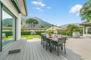 a wooden deck with a table and chairs on it at La Rotonda Villa with Pool and Jacuzzi in Maroggia