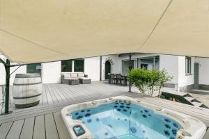 a hot tub on the deck of a house at La Rotonda Villa with Pool and Jacuzzi in Maroggia