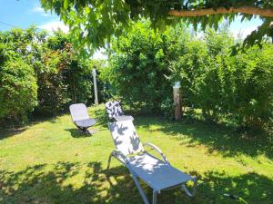 a bench and a chair sitting in a yard at Maison venitia 14 personnes in Aussonne