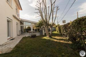 a backyard of a house with a tree at Maison venitia 14 personnes in Aussonne +71 photos