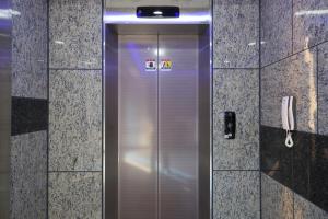a metal shower door in a bathroom with a phone at Daecheon Sea Joa Pension in Boryeong