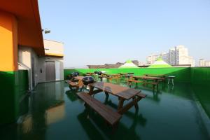 a group of tables and benches on the roof of a building at Daecheon Sea Joa Pension in Boryeong +1 photo