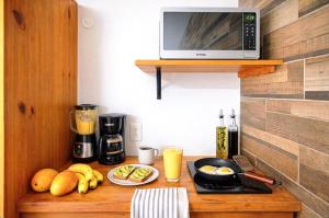 a kitchen counter with a microwave and some fruit on it at Centro Mornings, King & 2BR Suites, Sleeps 2-8, Kitchen WiFi AC, Beach, 5th Ave, ADO & Ferry 4 Min in Playa del Carmen