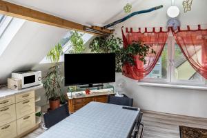a dining room with a table and a tv at A Casa Alfred Kemmern in Kemmern