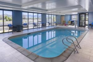 a pool in a hotel lobby with chairs and tables at Home2 Suites By Hilton Carson City in Carson City