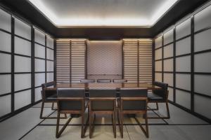 a dining room with a table and chairs and windows at Hinode Hills Niseko Village in Niseko