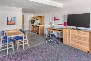 a living room with a desk and a flat screen tv at Home2 Suites By Hilton Carson City in Carson City