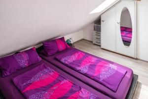a room with a bed with purple and pink sheets at A Casa Alfred Kemmern in Kemmern