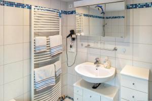 a white bathroom with a sink and a mirror at A Casa Alfred Kemmern in Kemmern +21 photos