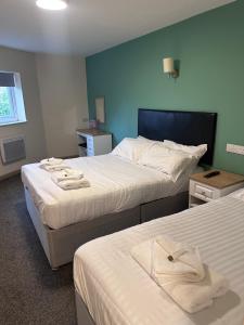 a hotel room with two beds with towels on them at The Cotteridge Inn in Birmingham