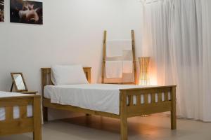 a bedroom with a wooden bed with white sheets at El Cielo Resort in Dauin