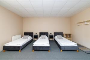 a room with three beds in it at Air Kaunas apartment in Karmėlava