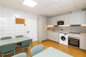 a kitchen with a table and chairs and a washing machine at Air Kaunas apartment in Karmėlava