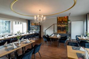 a restaurant with tables and chairs and a chandelier at Sweet Hotel Da Giovanni in Gladenbach