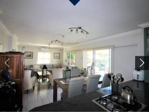 a kitchen and living room with a table and chairs at Beautiful Lagoon House in Blythedale