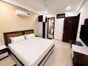 a bedroom with a white bed and a television at Tranquil Bliss in Jāmb