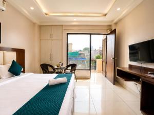a hotel room with a bed and a television at The Milford Noida in Noida